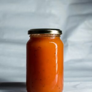 A glass jar of golden apricot jam